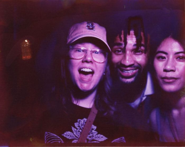 Three friends laughing together in a color portrait made at a public event